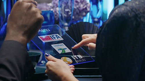 Imagefilm Messe Berlin Eine Hand hält ein Tablet, auf dem die Logos wichtiger Berliner Messen zu sehen sind